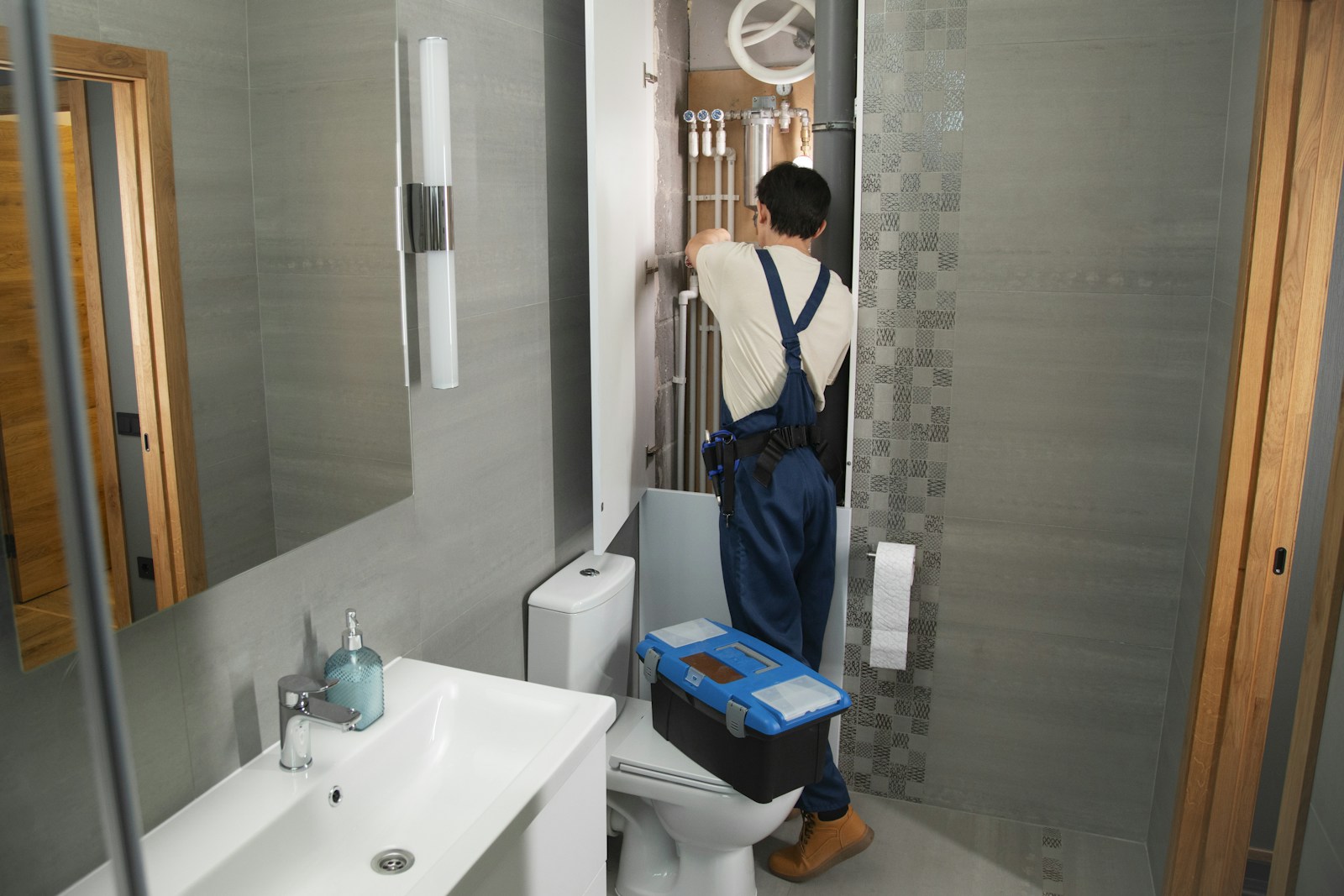 Plomero trabajando en baño · foto de referencia